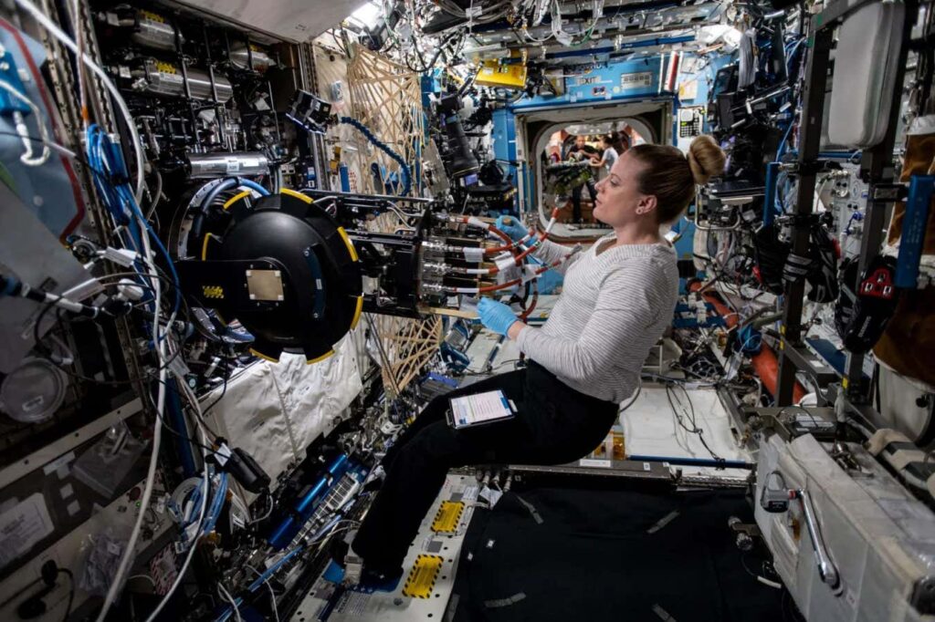 Astronaut inside the International Space Station using the combustion rack