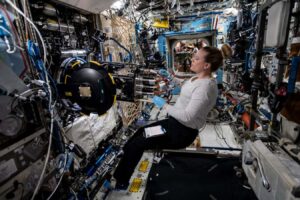 Astronaut inside the International Space Station using the combustion rack